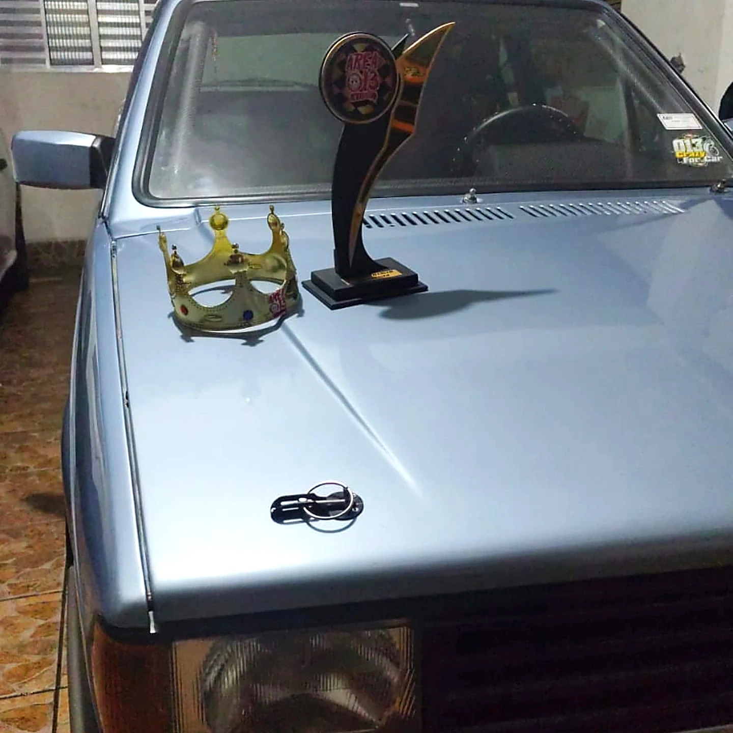 Troféu e coroa sobre o carro da Akira Motors