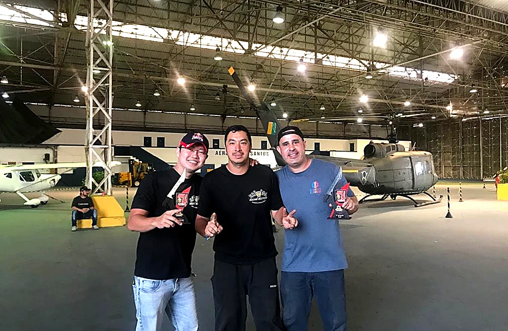 Equipe Akira Motors com troféus no hangar