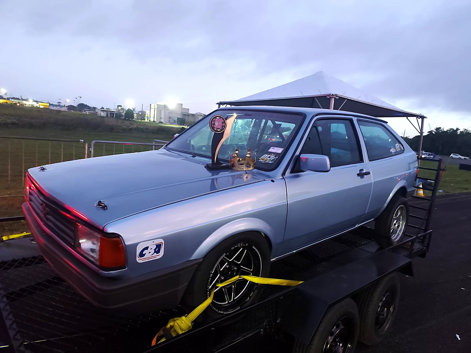 Gol azul da Akira Motors com troféu e coroa