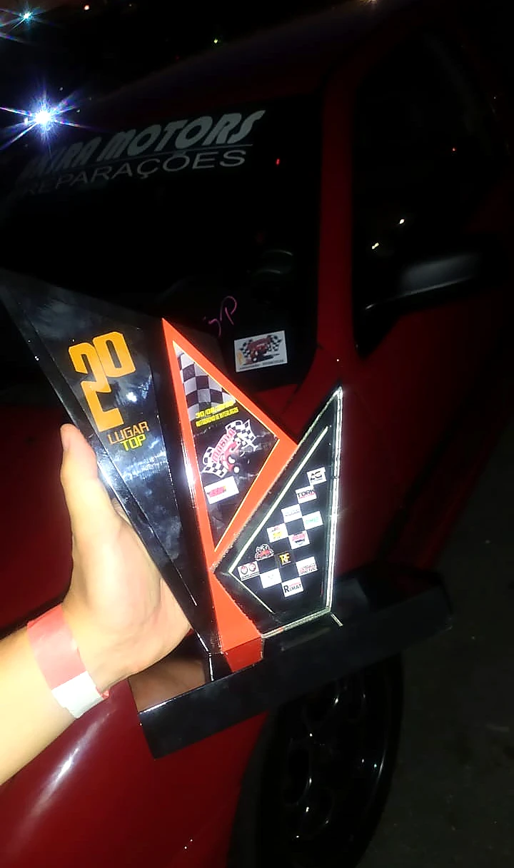Troféu de segundo lugar exibido à noite em frente ao carro